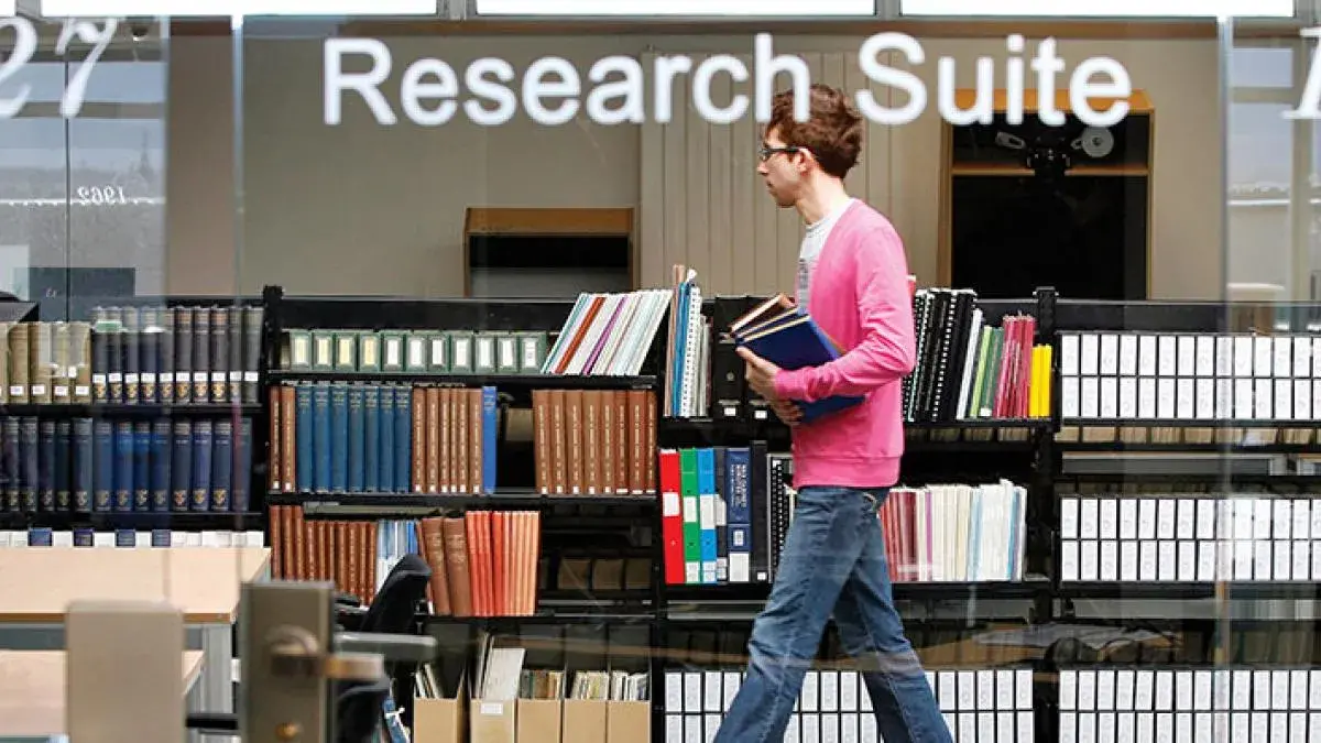 A student walking through the research suite in the Main Library.