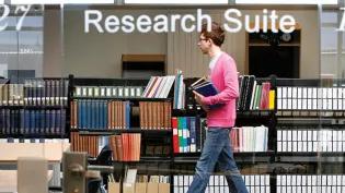 A student walking through the research suite in the Main Library.