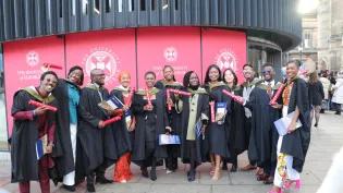 Students standing outside at graduation ceremony.