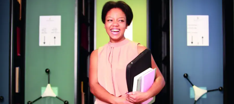 Student holding laptop and books