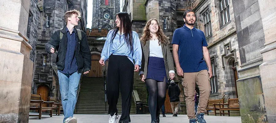 Four students walking at New College.