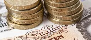 Pound coins on a ten pound note