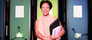 Student holding laptop and books