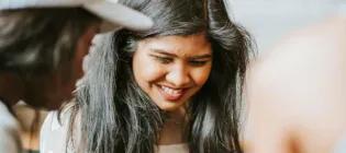 A close-up shot of a woman looking down and smiling.