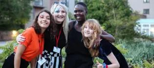 Four students holding each other's shoulders and smiling.
