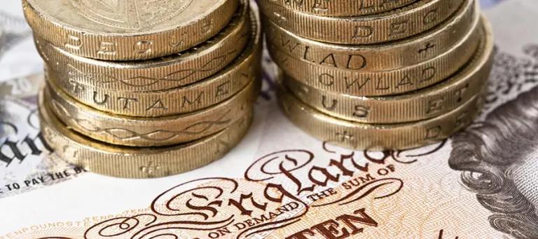 Pound coins on a ten pound note