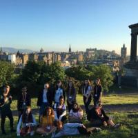 A group of participants is positioned for a photo on Calton Hill. A view on Edinburgh provides the background.
