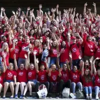 Group photo from a Sutton Trust Summer School graduation. All are wearing red University T-shirts.
