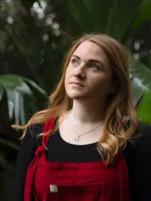 Laura poses for a photo with trees in the background
