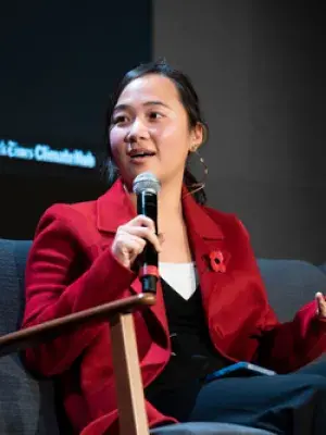 Lauren speaking into a microphone at a conference