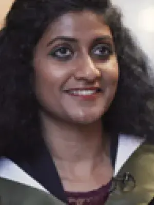 Photo of Asha Mathews in graduation robes