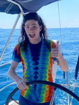 Student driving a boat and smiling
