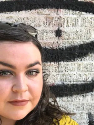 Headshot of Freya looking at camera against a graffiti wall background