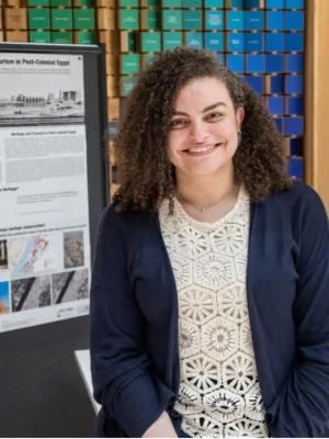 Headshot of student in front of research poster.