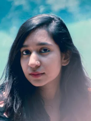 Woman looking at the camera against a blurred blue background